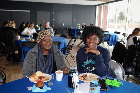 Two people sitting at a table with plates of breakfast food