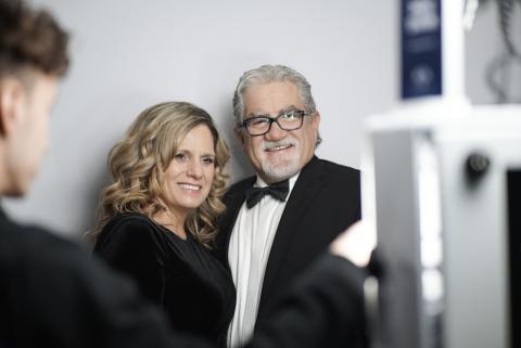 Two people smiling in front of professional photobooth