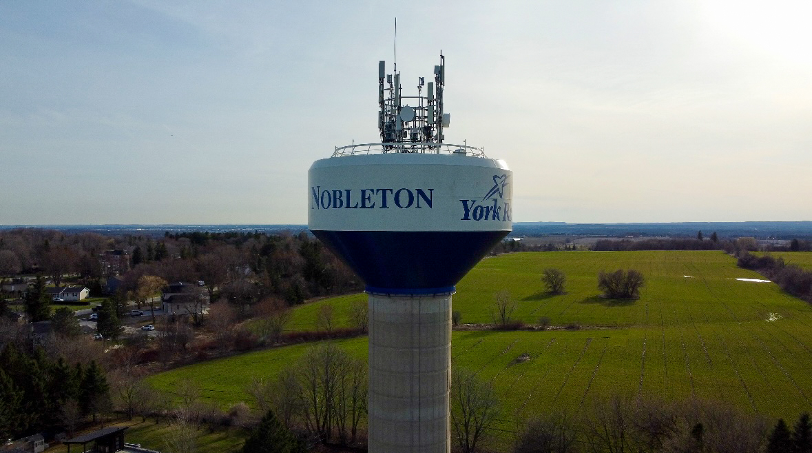 Nobleton Water Tower with green field behind it