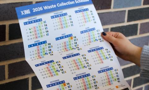 Updated 2026 Waste Collection Schedule held against a brick wall